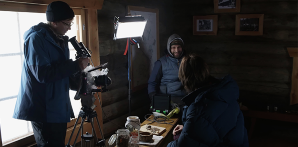 Behind the scenes Repolarille kuvatusta brändivideosta. Filmbutikin väki kuvaa puisen mökin sisällä.