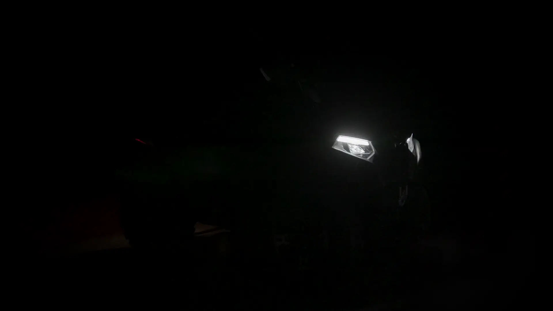Pimeässä huoneessa syttyy valo, paljastaen CF Moton C Force 625 mönkijän. Videolooppi.