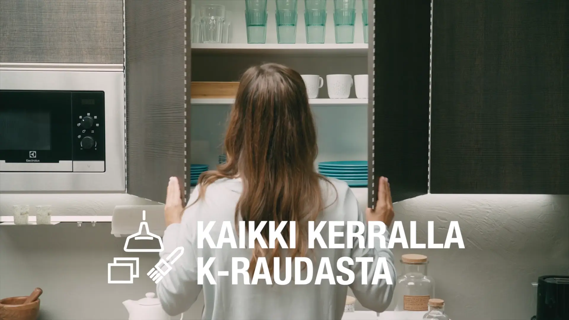 Nainen avaa Cello keittiön kaapin ovia, kaapissa laseja, mukeja ja lautasia Cellolle tuotetussa brändivideossa.